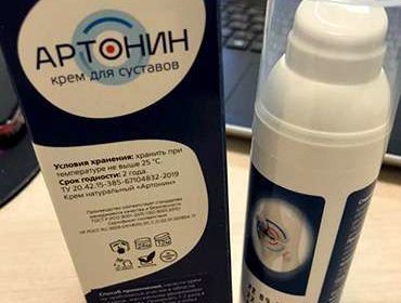 Упаковка и крем Артонин на столе.